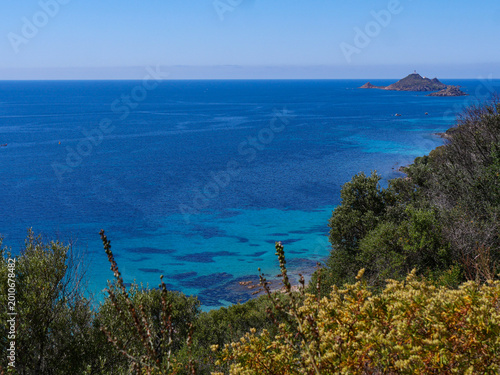 Bild auf Leinwand Wide turquoise sea view with distant Iles Sanguinaires lighthouse from Sentier d