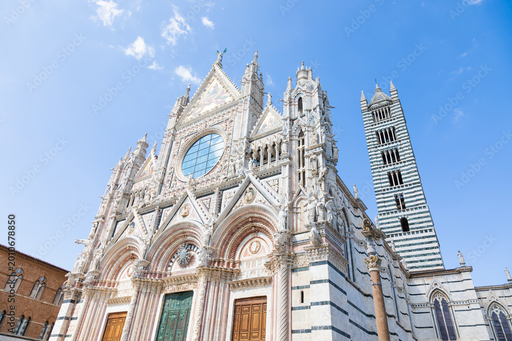 Naklejka premium Siena cathedral in Italy. White marbles with blue sky, famous landmark of Tuscany.
