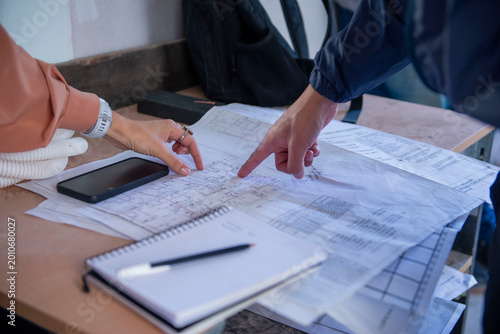 Architects hands pointing on house blueprint plans