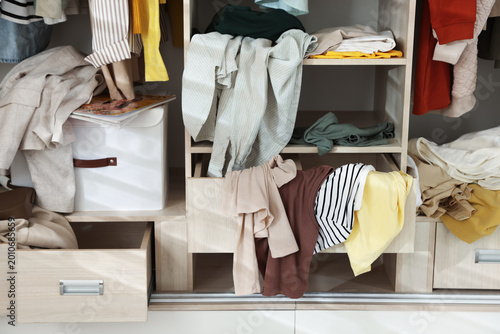 Fotografie Many different messy clothes in wardrobe indoors