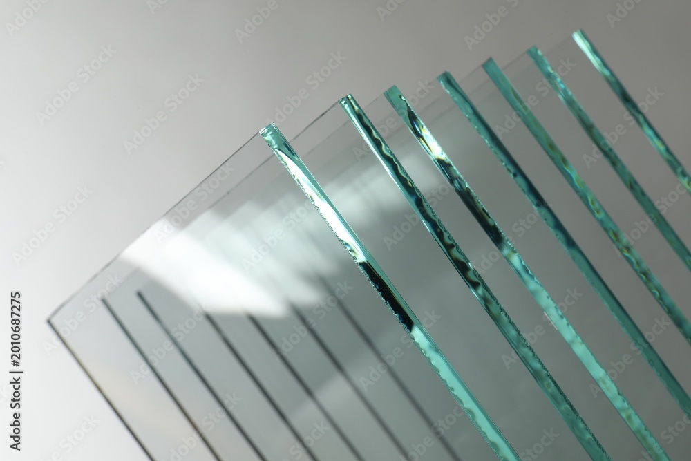 Naklejka premium Many clean glass sheets on light grey background, closeup