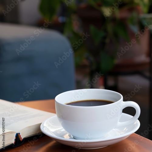 Coffee Cup on a Table Next to a Book During Morning Light in a Cozy Room Setting