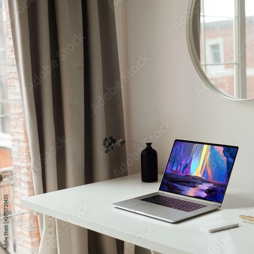 Laptop on a White Desk With Colorful Screen and Vase in a Modern Indoor Space...
