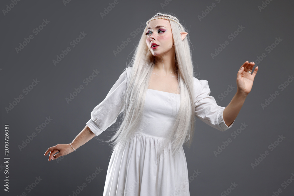 Fototapeta premium Beautiful girl dressed as elf on grey background