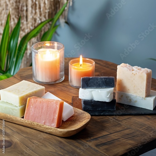 Different Types of Handmade Soap and Candles on a Wooden Table With Plants in...