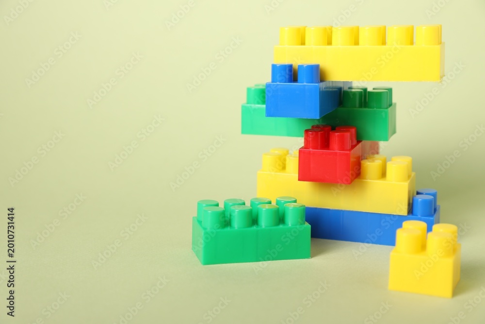 Naklejka premium Construction toy. Building blocks on pale green background, closeup. Space for text