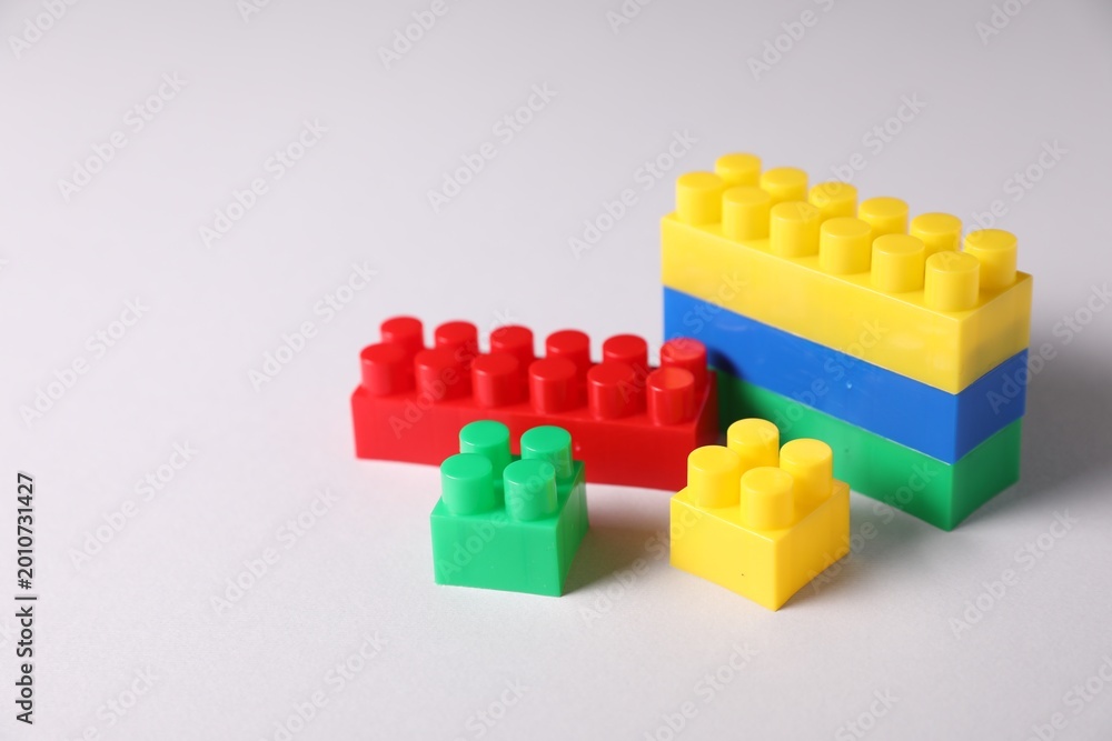 Fototapeta premium Construction toy. Building blocks on light background, closeup. Space for text