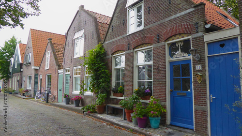 Row of old brick houses with detailed windows and lantern, Edam