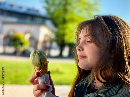 Teenage Girl Enjoying Ice Cream in a Waffle Cone Outdoors On A Sunny Day.