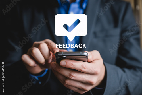 Valokuva Feedback and review concept with businessman using smartphone, mobile app icon