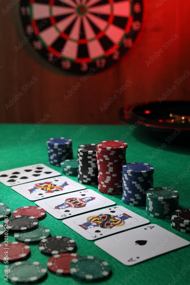Fototapeta premium Casino chips and playing cards on green table, closeup