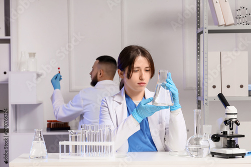 Young chemists with flask and test tubes of water samples in laboratory