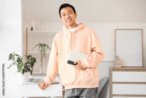 Young Asian man with notebo...
