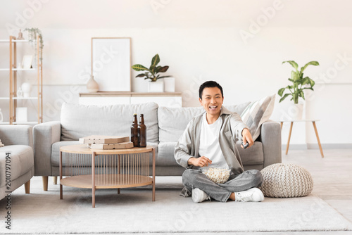 Young Asian man with remote...