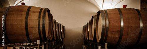 Tableau sur toile Wooden barrels stored in a cellar, showcasing the process of aging wine in a win