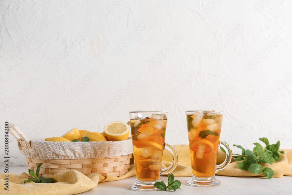 Fototapeta premium Glass cups of fresh iced tea on light background