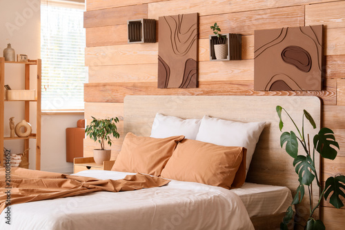 Bilde på lerret Interior of stylish bedroom with comfortable bed, bedside table and houseplants