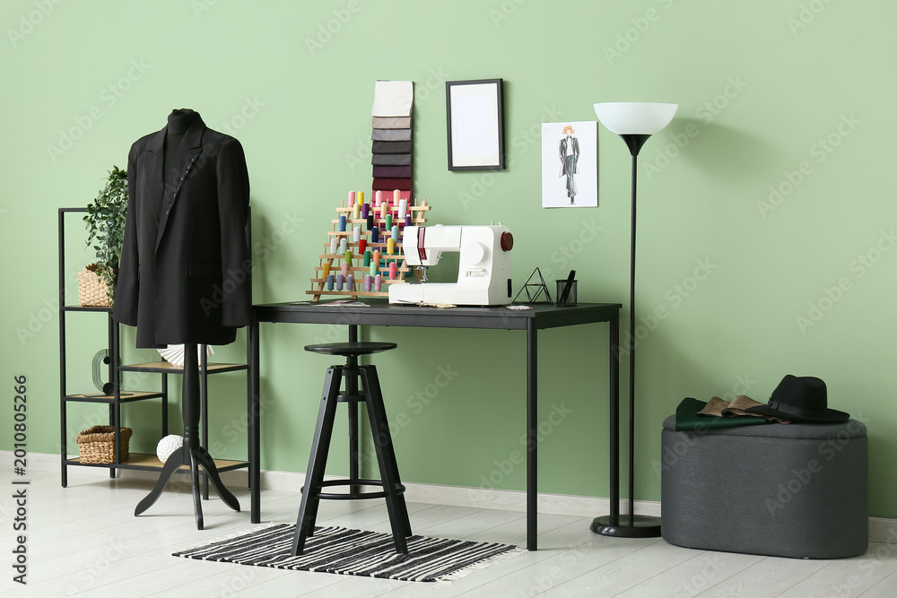 Fototapeta premium Interior of atelier with tailor's workplace, shelf unit and mannequin