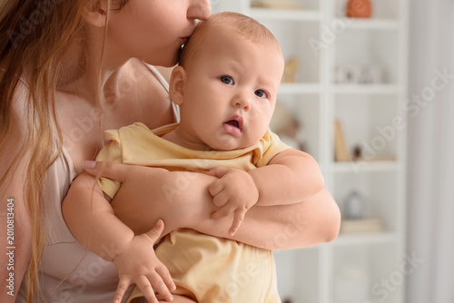 Mother kissing her little b...