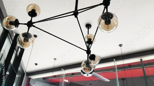 Modern ceiling chandelier lights in restaurant interior, warm lighting ambiance