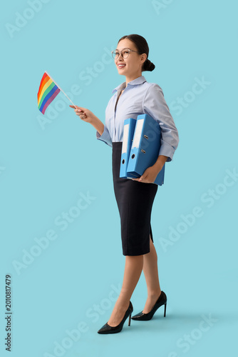 Asian businesswoman with LGBT flag and folders on blue background