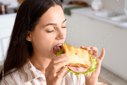 Young woman eating tasty sa...