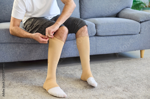 Quadro su tela Man wearing compression socks for varicose veins