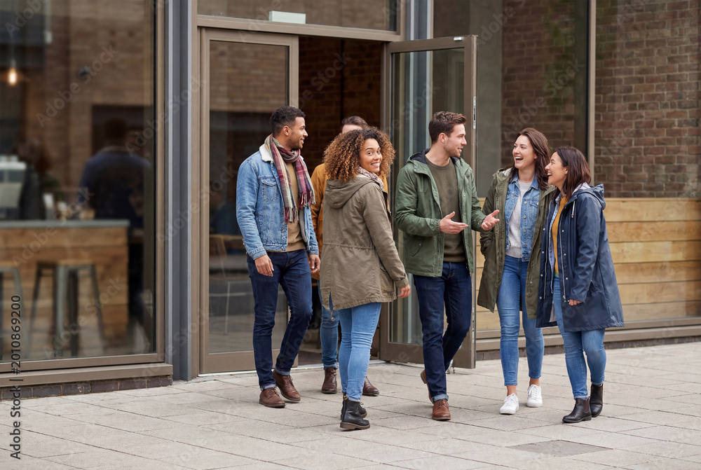 Fototapeta premium Friends walking together outside an urban building entrance