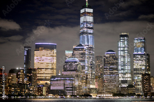 City Lights Flicker Over River. Soft Illuminated Skyline Reflects Calm Nocturnal City Atmosphere