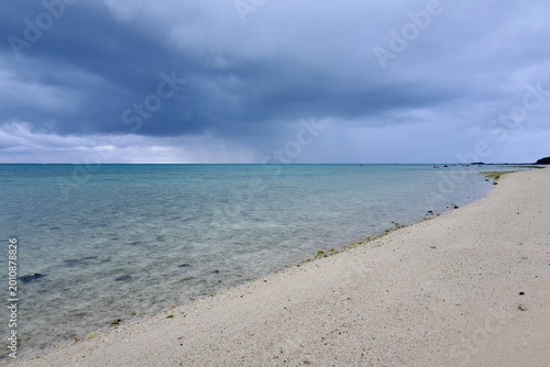 Fotografie Storm clouds and rain squall approaching over the emerald sea of Ishigaki Island