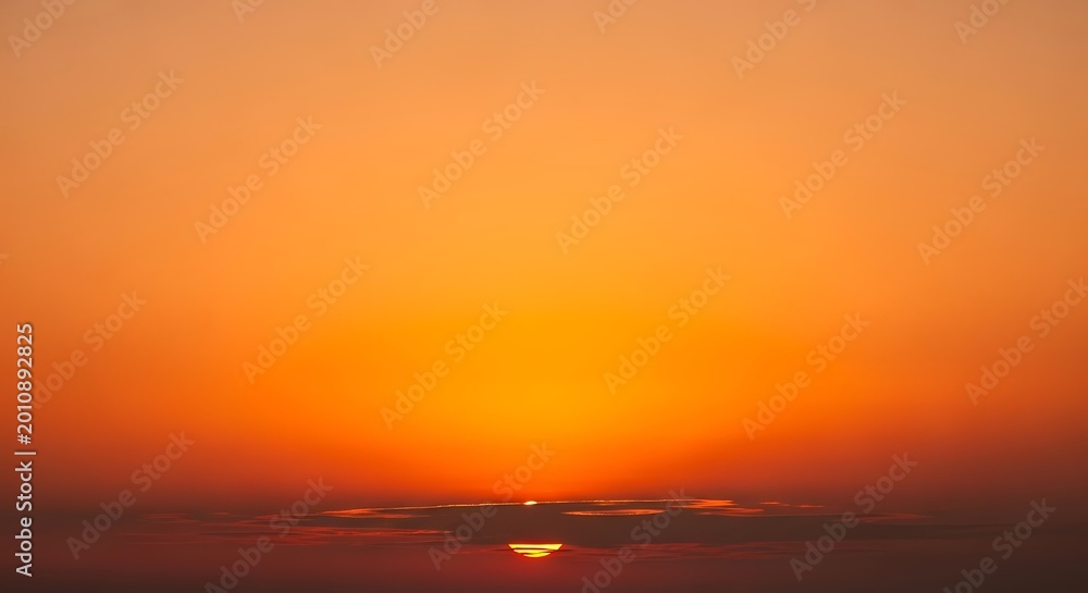 Obraz premium Sunset illuminates the horizon with warm orange light rays.