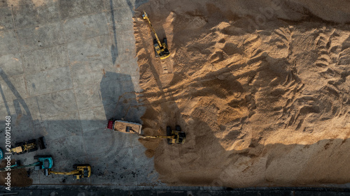 Fotografia Large pile of wood chips for plywood production being loaded onto truck by excavator