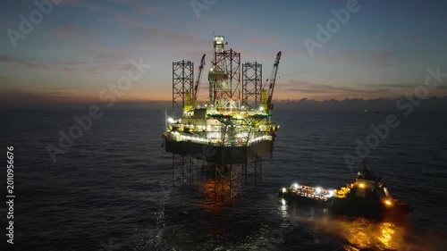 Aerial top view of offshore jack up rig and offshore platform during sunset for oil and gas exploration and production. 
