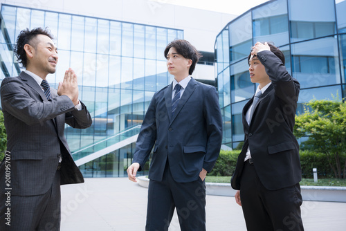 Photography 上司の急な仕事、無茶ぶりの無理なお願いに、ドン引きする困る若手社員　ビルの前の屋外で会話するビジネスパーソンイメージ　