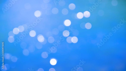 Deep blue bokeh sunlight reflections on water, silent abstract dreamy background footage