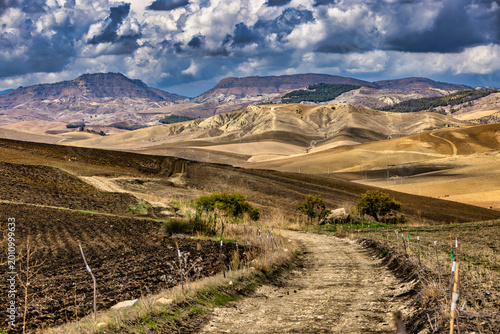 Foto Dry mountain landscape in the Madonie Mountains, Sicily, Italy, with winding dirt track through rolling hills