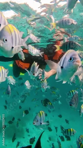 Happy couple in snorkeling mask dive underwater with tropical fishes in coral reef sea in Weh Island Sabang, Indonesia. Show by hands divers sign of love and heart. 