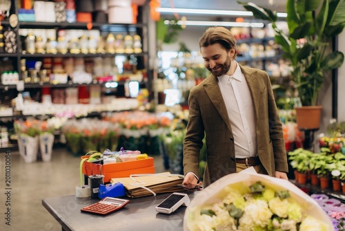 Man making contactless payment for flowers in shop