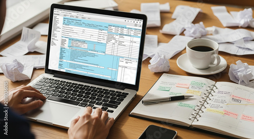 Stressful Tax Filing From Messy Desk Shown With Laptop With Digital File Being Filled While Coffee