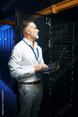 Photography Mature, man or server room with laptop for network security, maintenance or repair service