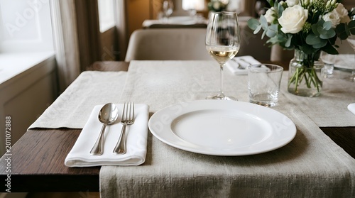 Elegant Table Setting for Dinner with White Plate, Wine Glass and Flowers