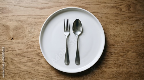 Empty White Plate with Fork and Spoon on Wooden Table - Top View