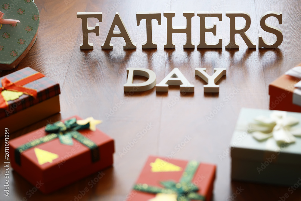 Fototapeta premium Fathers Day Celebration with Gifts and Decorative Letters on Wooden Background