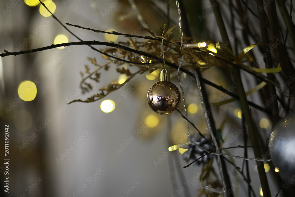 Obraz premium Golden Christmas Decorations on Tree Branches with Twinkling Lights in Background