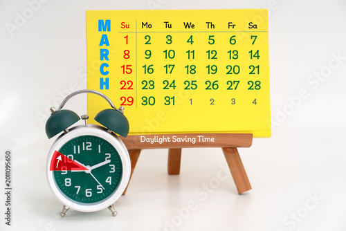 Photography Daylight saving time concept with March calendar and alarm clock adjusting one h