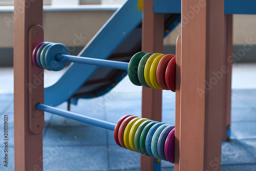 Colorful abacus beads on a preschool playground toy representing learning, childhood and early education play