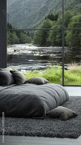 Bedroom retreat offers a serene environment with a plush gray bed and soft carpet positioned directly beside a wall of glass looking out onto a lush forest and a flowing river in the valley.