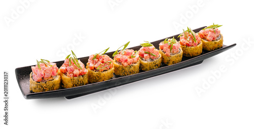 Bilde på lerret Sushi rolls served on a black plate with fish and green onions on top