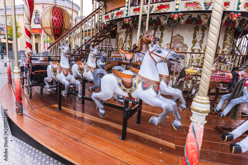 Obraz na plátně Vintage carousel with ornate white horses at an amusement park