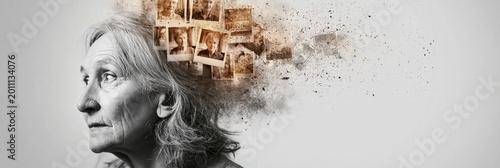 Aged woman losing memories, old photographs disintegrating from head representing dementia and memory loss
